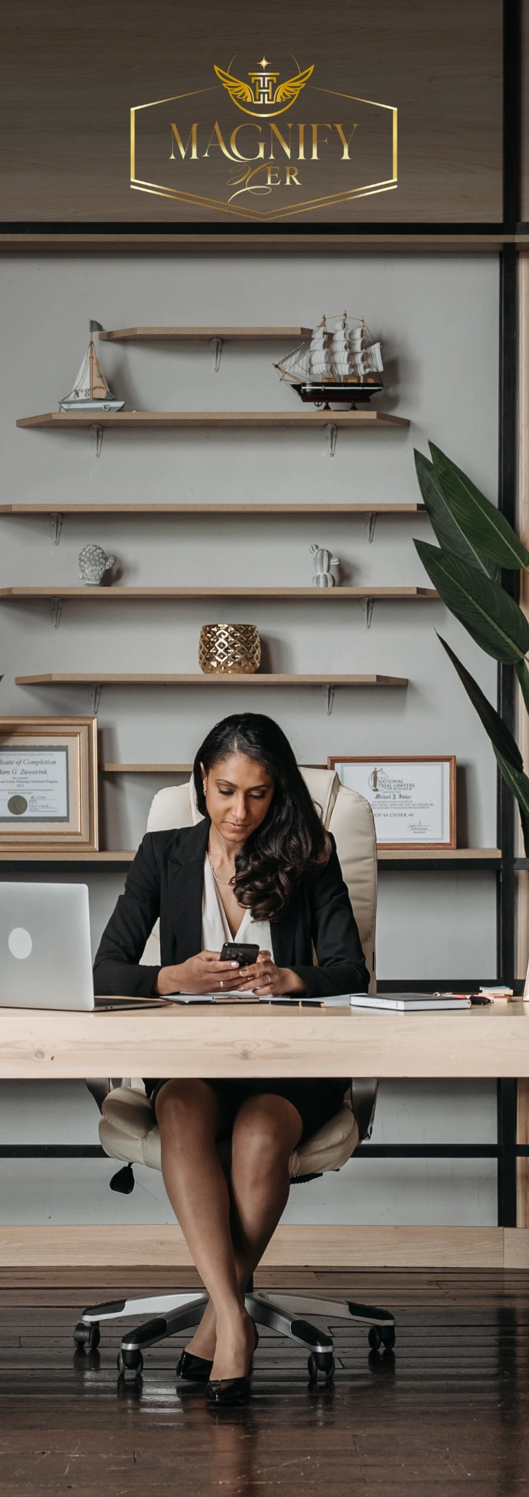 Magnify Her - Business woman sitting in her office looking at the Grow on The Go Newsletter on her mobile phone.